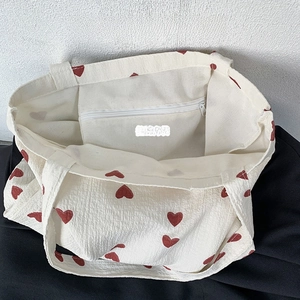Detailed top view of a canvas tote bag showing the interior compartment and zipper pocket