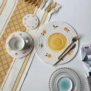Woven cotton rope round placemat with orange citrus print on a cozy dining table