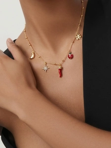 Collier doré porté avec breloques piment, coccinelle et trèfle à quatre feuilles