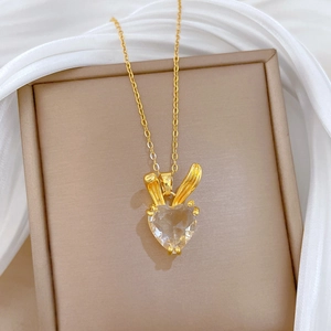 Close-up of golden bunny ear heart crystal necklace on jewelry box with silk background
