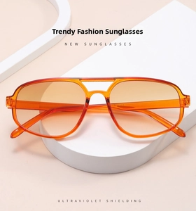 Detail of pilot sunglasses with orange translucent frames and gradient protective lenses