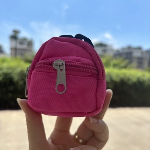 Mini rose red backpack coin purse keychain held in hand showing its compact size