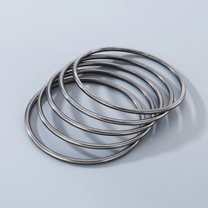 Macro detail of stacking gunmetal gray stainless steel bangles in minimalist round wire design