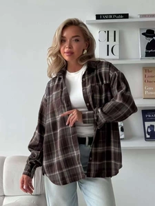 Detailed texture of brown plaid flannel shirt with button-down collar and relaxed fit