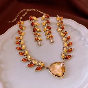 Vintage gold wheat ear necklace set with amber rhinestones on an elegant plate