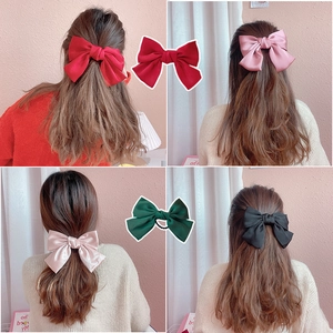 Oversized satin bow hair clips in red, pink, green, and black for elegant hairstyling
