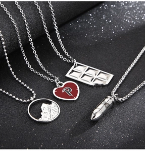 Détail macro de pendentifs argentés aux formes de cœur, montagne et chocolat