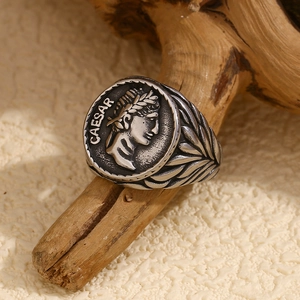 Macro detail of vintage silver coin ring with Caesar relief on weathered wood