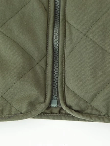 Detail view of military green quilted bomber jacket with resin zipper and diamond stitching