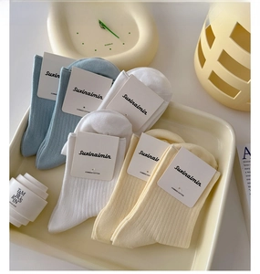Detail of combed cotton mid-calf socks with vertical ribs in blue, white and beige