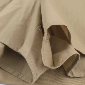 Vue détaillée de la texture du tissu kaki haute densité et de la finition des coutures