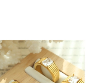 Detail of a vintage gold-toned ring with a ribbed band and a clear rectangular gemstone