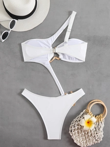Close-up of white one-shoulder swimsuit with elegant gold metal ring and buckle details