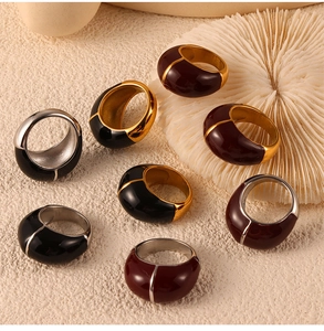 Macro shot of wide-band geometric rings with burgundy enamel and gold plating detail