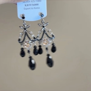 Detailed macro view of retro 925 silver long fringe earrings with pearls and crystal inlay