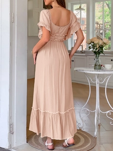 Détail de la robe longue dos nu rose avec bordures à volants et tissu fluide doux