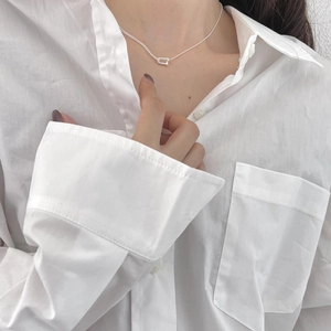 Close-up of a minimalist 925 sterling silver U-shaped pendant necklace on a model