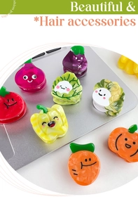 Close-up of cute dopamine vegetable-shaped hair clips scattered on a laptop