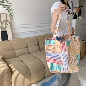 Detail of colorful striped corduroy tote bag showing large capacity and soft texture