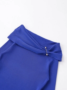 Detailed close-up of royal blue ribbed knit top with a stylish gold metal bar fastener