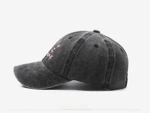 Detail of vintage washed cotton baseball cap with pink embroidery and retro acid wash texture