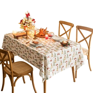 Christmas snowman and tree print tablecloth on a festive wooden dining table setting
