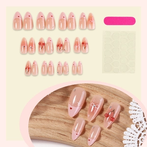 Pink gradient press-on nails set with cherry and bow designs in almond shape