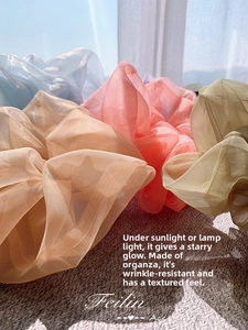 Detailed view of sheer organza hair scrunchies with pearlescent finish in pastel colors