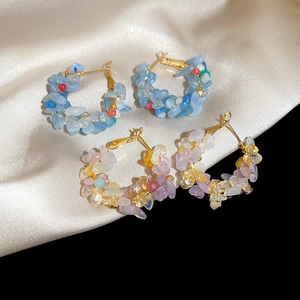 Detail of silver needle hoop earrings featuring mixed colorful natural stones and pearls
