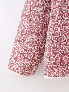 Detail of floral printed quilted jacket cuff showing stitching and fabric texture
