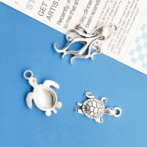 Macro view of silver ocean animal charms featuring octopus and sea turtle metal details