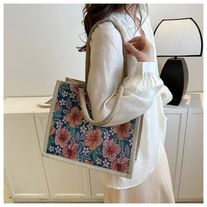 Detail of a large floral jacquard tote bag with ethnic red and orange flower patterns