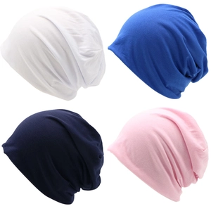 Detail view of slouchy beanies in white, royal blue, navy, and pink colors