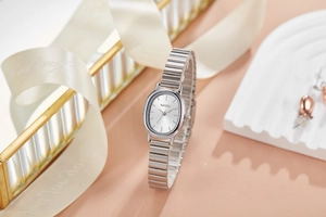 Dettaglio di un elegante orologio al quarzo ovale in argento su un vassoio decorativo
