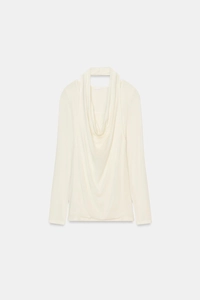Close-up of cream white long-sleeve top with elegant cowl neck and silky draped fabric
