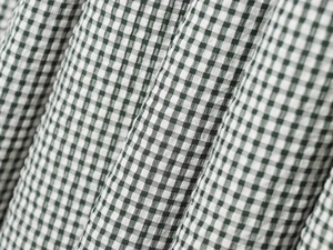 Vue détaillée de la texture du tissu seersucker à carreaux verts et blancs fins