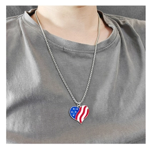 Close-up of a silver heart necklace featuring a US flag pattern on a model's neck