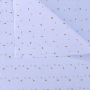 Close-up of light blue tissue paper with gold polka dots for floral gift wrapping