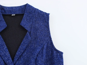 Close-up of dark blue tweed sleeveless top texture with V-neckline and classic lapel