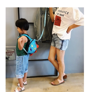 Blue dinosaur kids backpack with safety leash shown in a parent-child walking scene