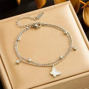 Macro detail of silver double-layered butterfly pendant bracelet with zircons and s.steel stamp