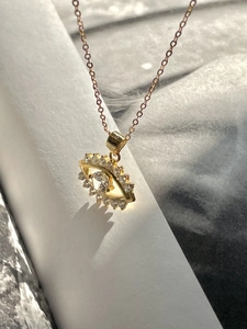 Detailed view of evil eye pendant with sparkling zircons and 18K gold plating