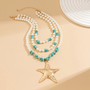 Close-up of golden starfish pendant with triple-layer pearl and blue stone beads