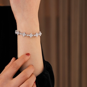 Detailed close-up of a silver clover bracelet with sparkling pave-set cubic zirconia crystals
