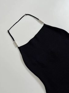 Detailed knit texture and silver bead straps on black halter top shown in a flat lay view