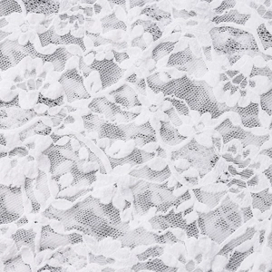 Macro shot of white floral lace fabric with detailed embroidery for a sexy halter jumpsuit