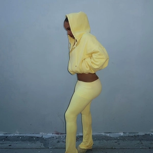 Seitenansicht von hellgelbem Strick-Hoodie und Schlaghose an einem Modell