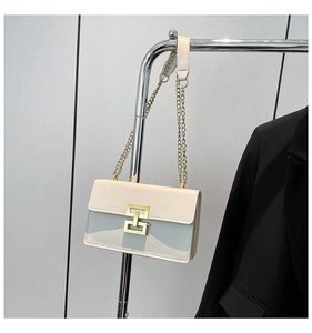 Close-up of off-white leather bag featuring a chic gold square clasp and chain strap