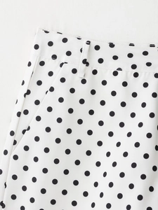 Détail du motif à pois noirs sur tissu blanc avec passant de ceinture et coutures