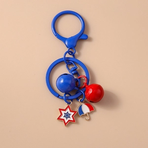 Close-up of metal keychain with blue bells and colorful star and umbrella pendants